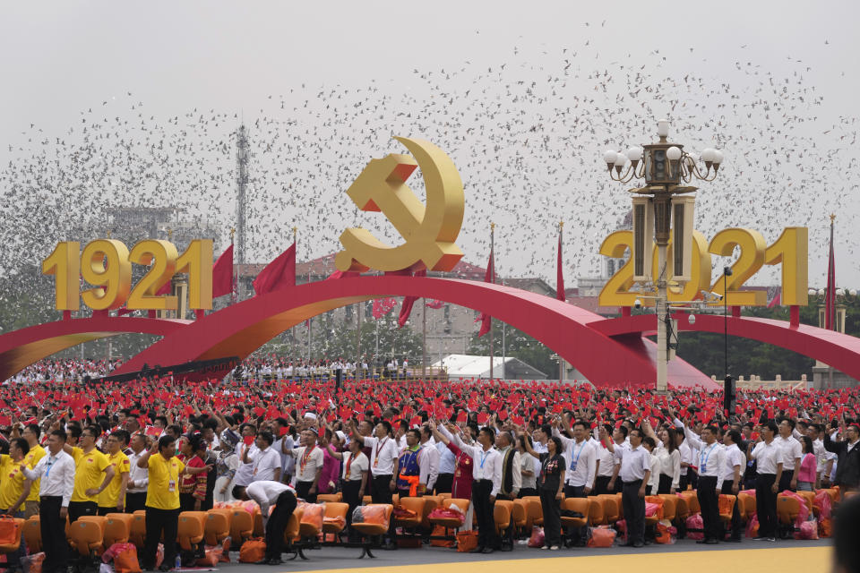 Attendees wave Chinese flags during a ceremony at Tiananmen Square to mark the 100th anniversary of the founding of the ruling Chinese Communist Party in Beijing Thursday, July 1, 2021. (AP Photo/Ng Han Guan)