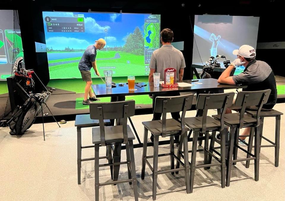 Golfers play the virtual version of the game at X-Golf in Jackson Township, one of several restaurants, bars and businesses featuring golf simulators in the Canton area.