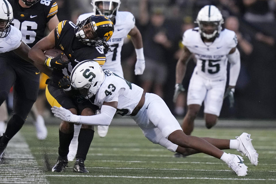 Iowa wide receiver Diante Vines (0) is tackled by Michigan State defensive back Malik Spencer (43) after catching a pass during the first half of an NCAA college football game, Saturday, Sept. 30, 2023, in Iowa City, Iowa. (AP Photo/Charlie Neibergall)