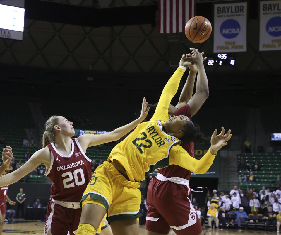 Baylor guard Bella Fontleroy (22) reaches back as Oklahoma forward Liz Scott (34) pulls down a rebound during the first half of an NCAA college basketball game Tuesday, Feb. 7, 2023, in Waco, Texas. At left is Oklahoma guard Aubrey Joens (20). (Rod Aydelotte/Waco Tribune-Herald via AP)