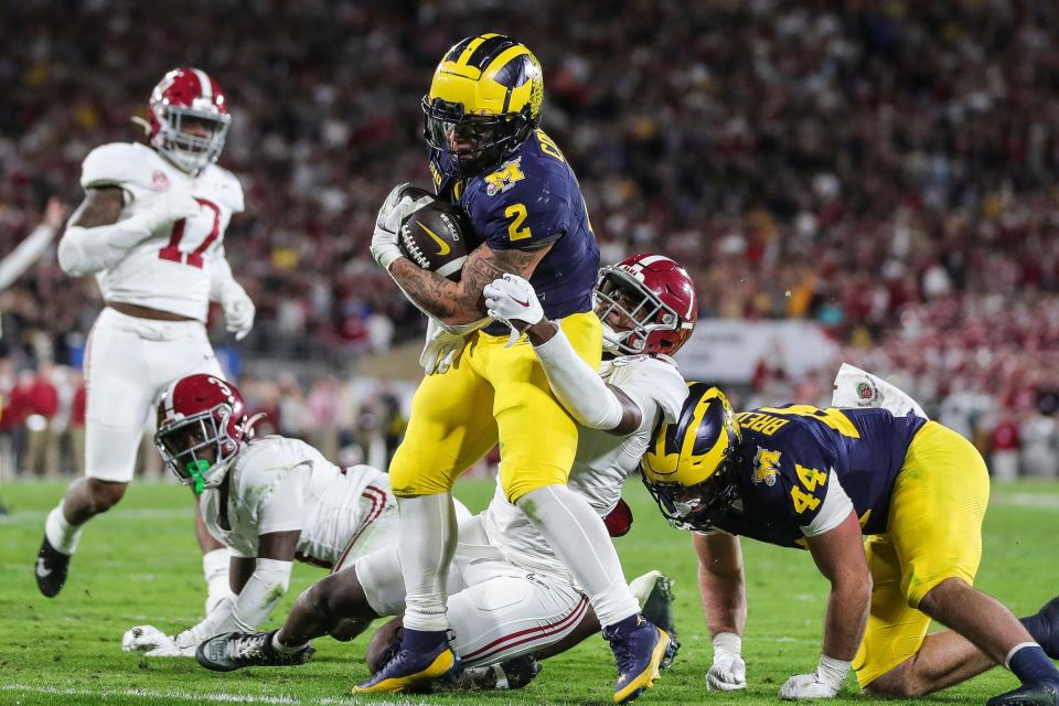 Michigan running back Blake Corum (2) runs into the end zone for a touchdown against Alabama defensive back Kool-Aid McKinstry (1) in overtime of the Rose Bowl in Pasadena, Calif., on Monday, Jan. 1, 2024.