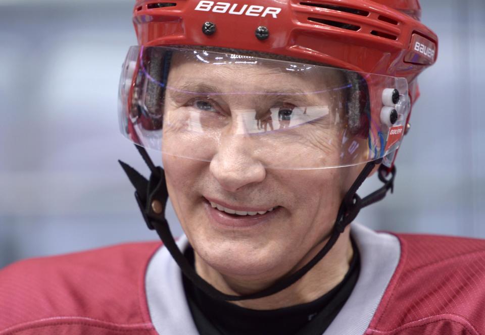 Russian President Vladimir Putin smiles though protective head gear as he plays a friendly hockey match between the Stars of the NHL 1 and the Stars of the NHL 2 teams at The Bolshoy Ice Dome, the part of the complex of facilities operated by the International Ice Hockey Federation (IIHF) at the Black Sea resort of Sochi, southern Russia, Saturday, Jan. 4, 2014. (AP Photo/RIA-Novosti, Alexei Nikolsky, Presidential Press Service)