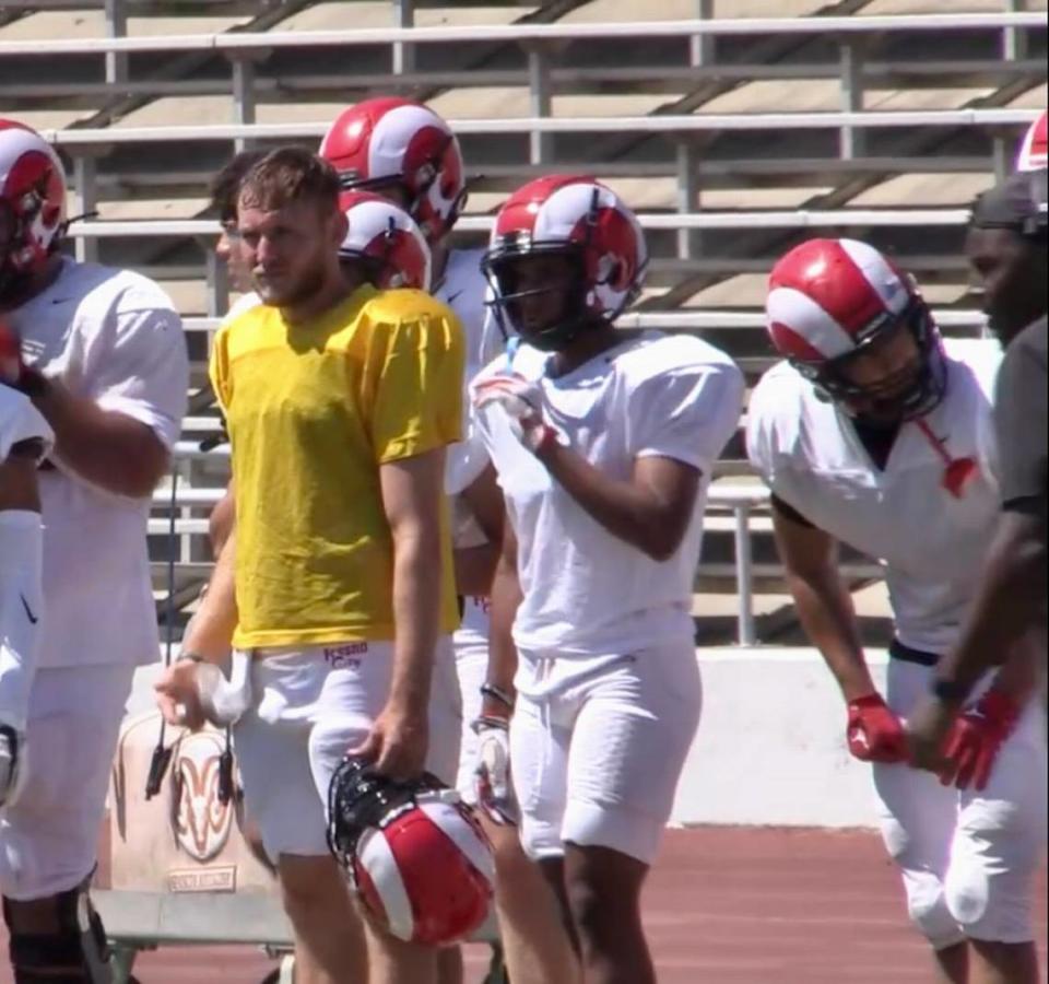 Fresno City College quarterback Alec Trujillo on the sideline with his teammates.