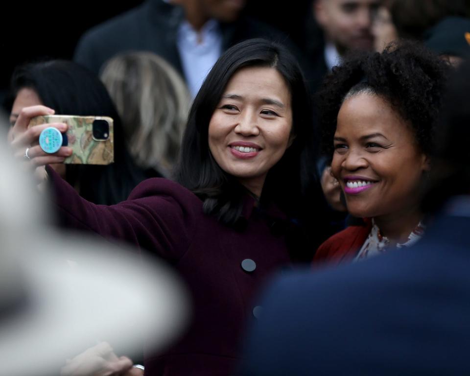 Boston Mayor Michelle Wu takes a selfie with former city mayor Kim Janey after the unveiling ceremony of "The Embrace," a sculpture dedicated to Rev. Martin Luther King Jr. and Coretta Scott King on Boston Common, Friday, Jan. 13,  2023.