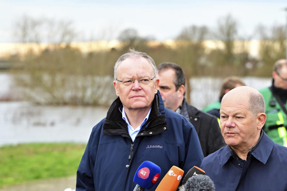 Federal Chancellor Olaf Scholz, right, and Stephan Weil, Minister President of Lower Saxony, give a press statement during their visit to the flood area at the confluence of the Weser and Aller rivers, Germany, Sunday, Dec. 31, 2023. Chancellor Olaf Scholz took a sightseeing flight in an air force helicopter to gain an impression of the flood situation in the north of Lower Saxony. (Philipp Schulze/dpa via AP)