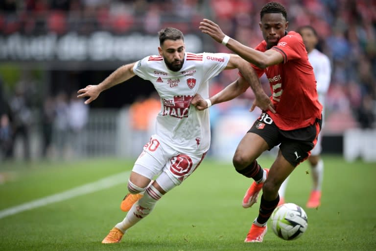 El defensor francés del Rennes Jeanuël Belocian (derecha) pugna por el balón con un jugador del Brest durante el partido de Ligue 1 entre ambos equipos en el Roazhon Park de Rennes, el 28 de abril de 2024 (Lou BENOIST)