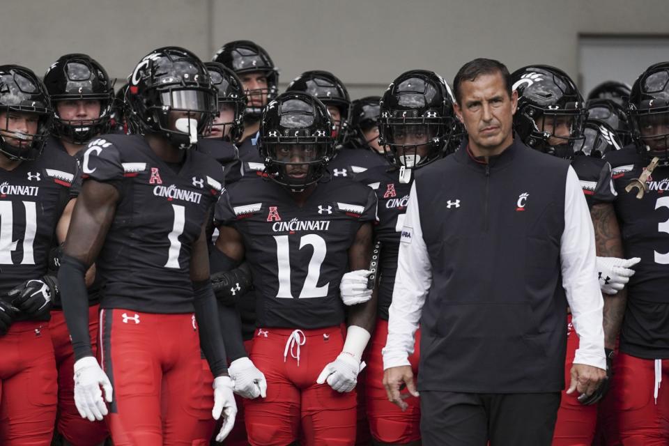 Cincinnati cornerback Ahmad Gardner (1) and coach Luke Fickell prepare to lead their team onto the field