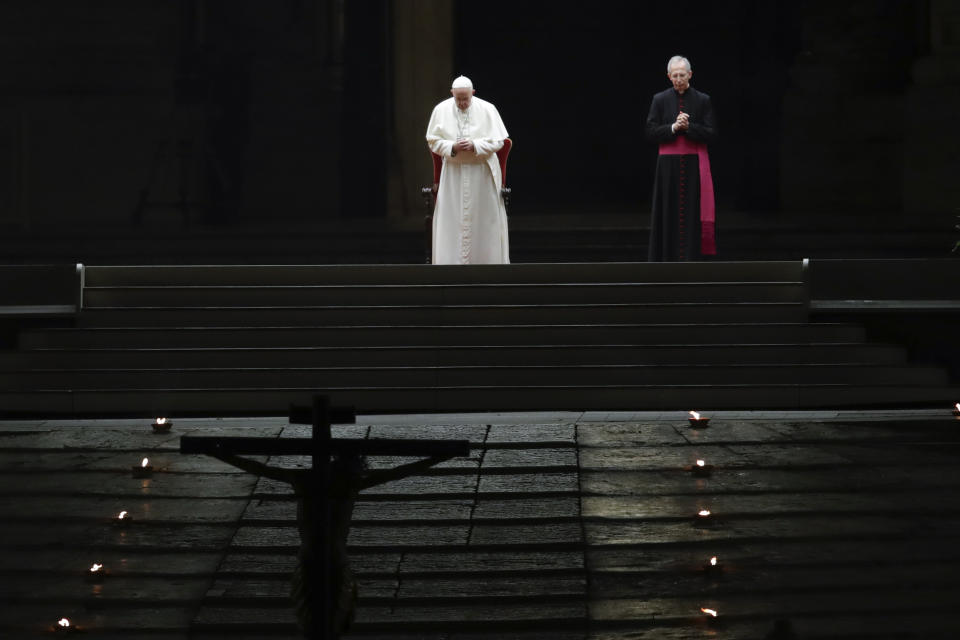 Pope Francis is flanked by Mons. Guido Marini, right, the Vatican master of liturgical ceremonies, as he leads the Via Crucis – or Way of the Cross – ceremony in St. Peter's Square empty of the faithful following Italy's ban on gatherings to contain coronavirus contagion, at the Vatican, Friday, April 10, 2020. (AP Photo/Alessandra Tarantino)