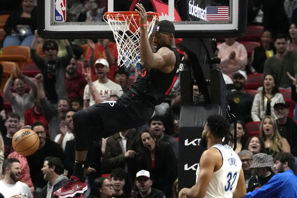Miami Heat center Bam Adebayo dunks over Minnesota Timberwolves center Karl-Anthony Towns (32) during the first half of an NBA basketball game, Monday, Dec. 18, 2023, in Miami. (AP Photo/Lynne Sladky)