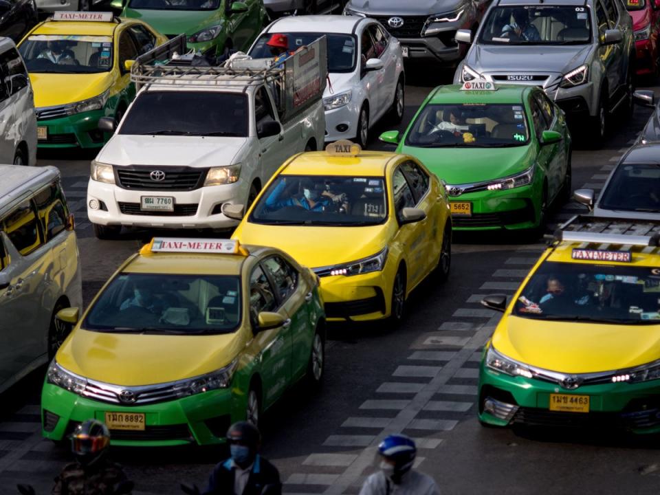 File. Taxis wait at a red light signal on a street in Bangkok on 10 November 2022 (AFP via Getty Images)