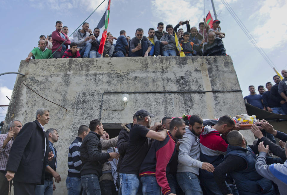Mourners carry the body of Palestinian Mohammed Shreteh during his funeral in the West Bank village of Mazraa al-Gharbiya, near Ramallah, Sunday, Nov. 11, 2018. Shreteh succumbed to his wounds that were sustained during clashes with Israeli soldiers in the village last month. (AP Photo/Nasser Nasser)