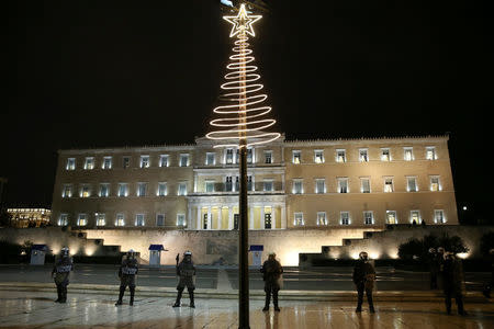 Riot police stand guard beneath a Christmas decoration in front of the parliament building during an anniversary rally marking the 2008 police shooting of 15-year-old student, Alexandros Grigoropoulos, in Athens, Greece, December 6, 2016. REUTERS/Alkis Konstantinidis