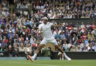 FILE - Roger Federer of Switzerland volleys a return to Victor Hanescu of Romania during their Men's first round singles match at the All England Lawn Tennis Championships in Wimbledon, London, Monday, June 24, 2013. (AP Photo/Anja Niedringhaus, File)