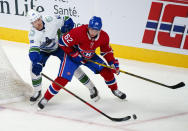 Vancouver Canucks' Elias Pettersson plays the puck away from Montreal Canadiens' Artturi Lehkonen (62) during the second period of an NHL hockey game, Monday, Nov. 29, 2021 in Montreal. (Paul Chiasson/The Canadian Press via AP)