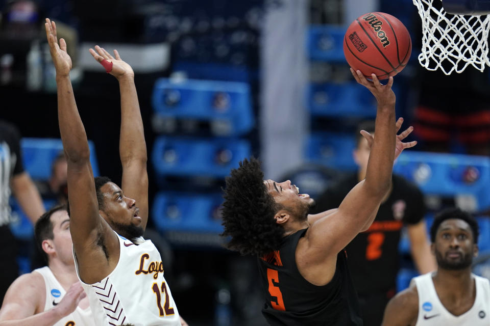 Oregon State guard Ethan Thompson (5) drives to the basket ahead of Loyola Chicago guard Marquise Kennedy (12) during the second half of a Sweet 16 game in the NCAA men's college basketball tournament at Bankers Life Fieldhouse, Saturday, March 27, 2021, in Indianapolis. (AP Photo/Jeff Roberson)