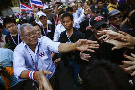 Anti-government protest leader Suthep Thaugsubanmarch (front L) reaches his hands out to his supporters during a rally at a major business district in Bangkok December 19, 2013. Anti-government protesters marched in Bangkok on Thursday in a bid to force Prime Minister Yingluck Shinawatra from office but their numbers appeared far smaller than earlier in the month, when she called a snap election to try to defuse the crisis. REUTERS/Athit Perawongmetha