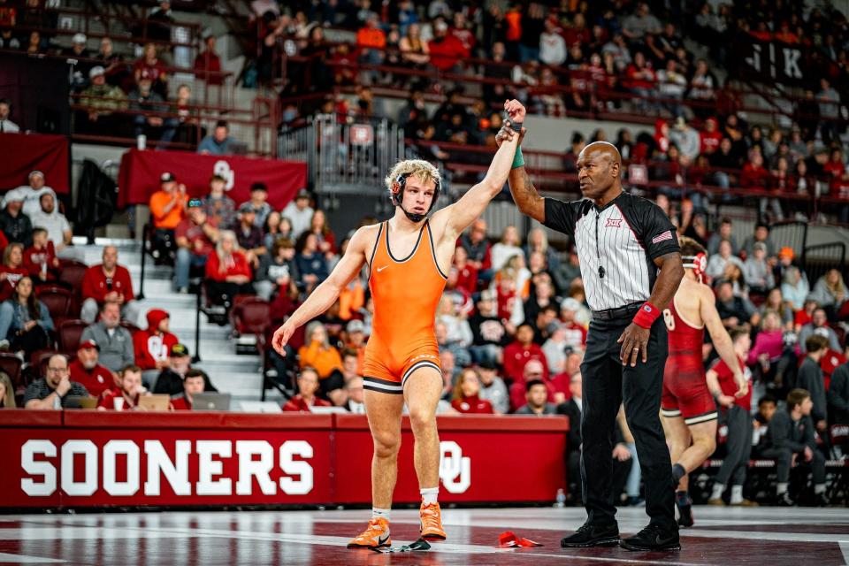 Oklahoma State 157-pounder Teague Travis gets his hand raised during the Cowboys' dual against OU on Sunday McCasland Field House in Norman.