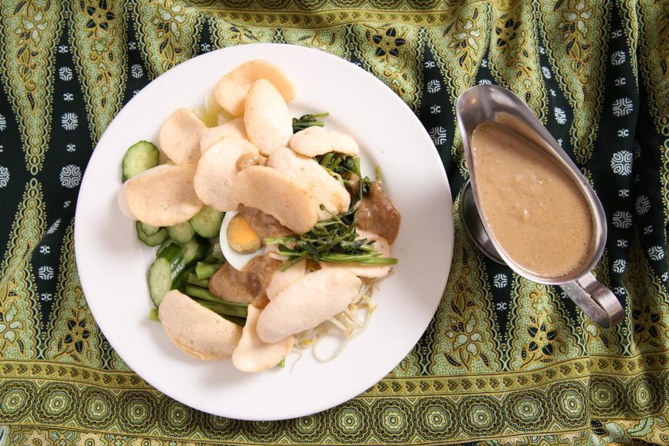 「印式沙拉」(gado gado)的蔬菜盤上放著蝦片，吃得時候要蘸特調花生醬一起入口，滑順香醇中還很清爽。（180元／份）
