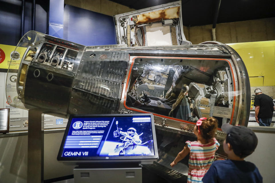 Visitors look on the Gemini VIII spaceship at the Armstrong Air & Space Museum, Wednesday, June 26, 2019, in Wapakoneta, Ohio. Very down to earth about most things, folks in this small western Ohio city are over the moon as they get ready to celebrate the 50th anniversary of the day they watched their hometown hero along with the world. Neil Armstrong put Wapakoneta on the map in July 1969 when he became the first human to walk on the moon. (AP Photo/John Minchillo)