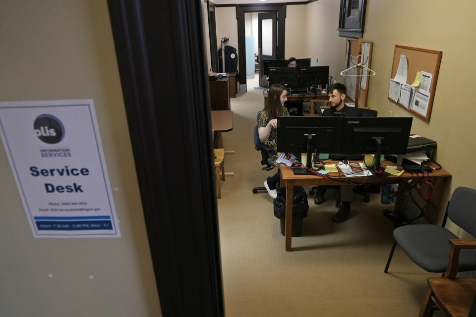 State Rep. Zooey Zephyr, left, speaks with an IT specialist to prepare for her first day of remote voting at the State Capitol, Thursday, April 27, 2023 in Helena, Mont. Zephyr was barred from participating on the House floor as Republican leaders voted Wednesday to silence her for the rest of 2023 session after she protested GOP leaders' decision earlier in the week to silence her. (AP Photo/Brittany Peterson)