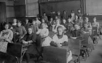 <p>Rows of well-behaved schoolchildren, seated neatly at their desks, pose for a photo in their classroom.</p>