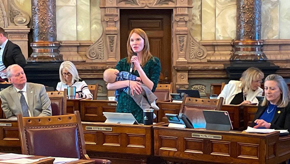 Rep. Kristen O’Shea, R-Topeka, holds her baby while she speaks from her desk on the floor of the House chamber at the Capitol in Topeka.