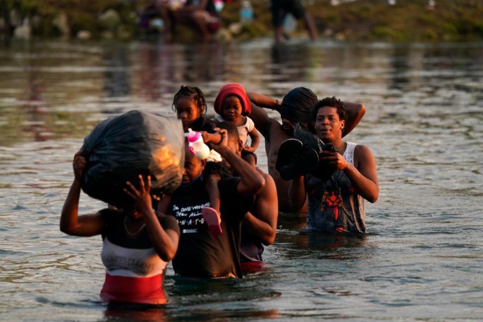 Migrants, many from Haiti, wade across the Rio Grande from Del Rio, Texas, to return to Ciudad Acuna, Mexico, Tuesday, 21 September 2021, to avoid deportation from the U.S (AP)