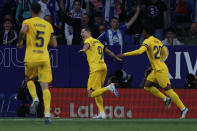 Barcelona's Robert Lewandowski, centre, celebrates after scoring his side's opening goal during the Spanish La Liga soccer match between Espanyol and Barcelona at the RCDE stadium in Barcelona, Sunday, May 14, 2023. (AP Photo/Joan Monfort)