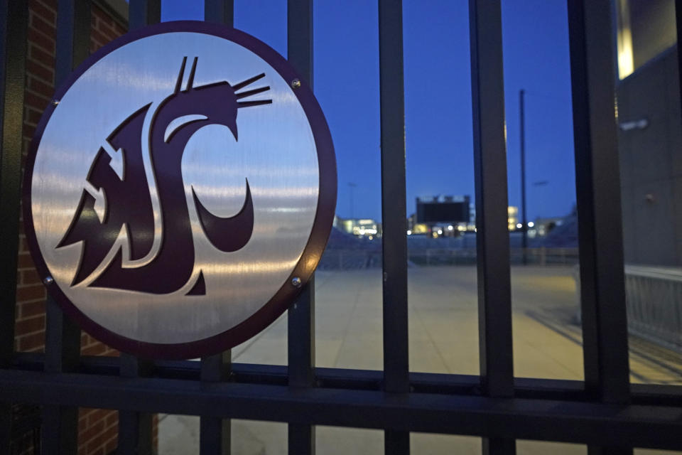 The Washington State Cougar logo is displayed on a gate at Martin Stadium, Monday, Oct. 18, 2021, in Pullman, Wash. Head football coach Nick Rolovich and four of his assistants were fired on Monday for refusing a state mandate that all employees get vaccinated against COVID-19, making him the first major college coach to lose his job over vaccination status. (AP Photo/Ted S. Warren)