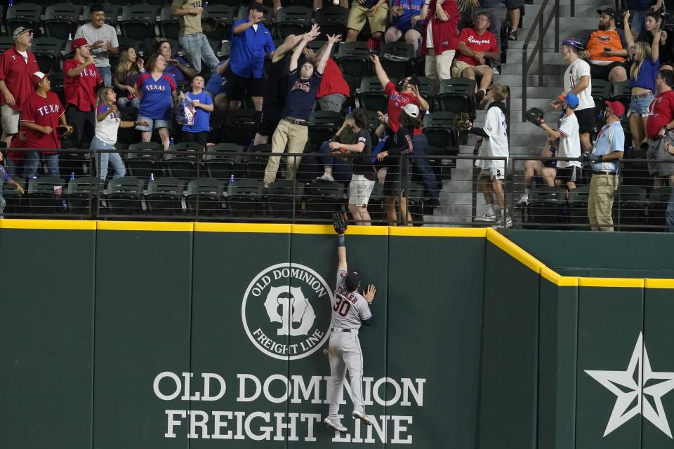 Houston Astros right fielder Kyle Tucker leaps but is well short of a three-run home run hit by Texas Rangers' Adolis Garcia during the 10th inning of a baseball game in Arlington, Texas, Friday, May 21, 2021. The Rangers won 7-5. (AP Photo/Tony Gutierrez)