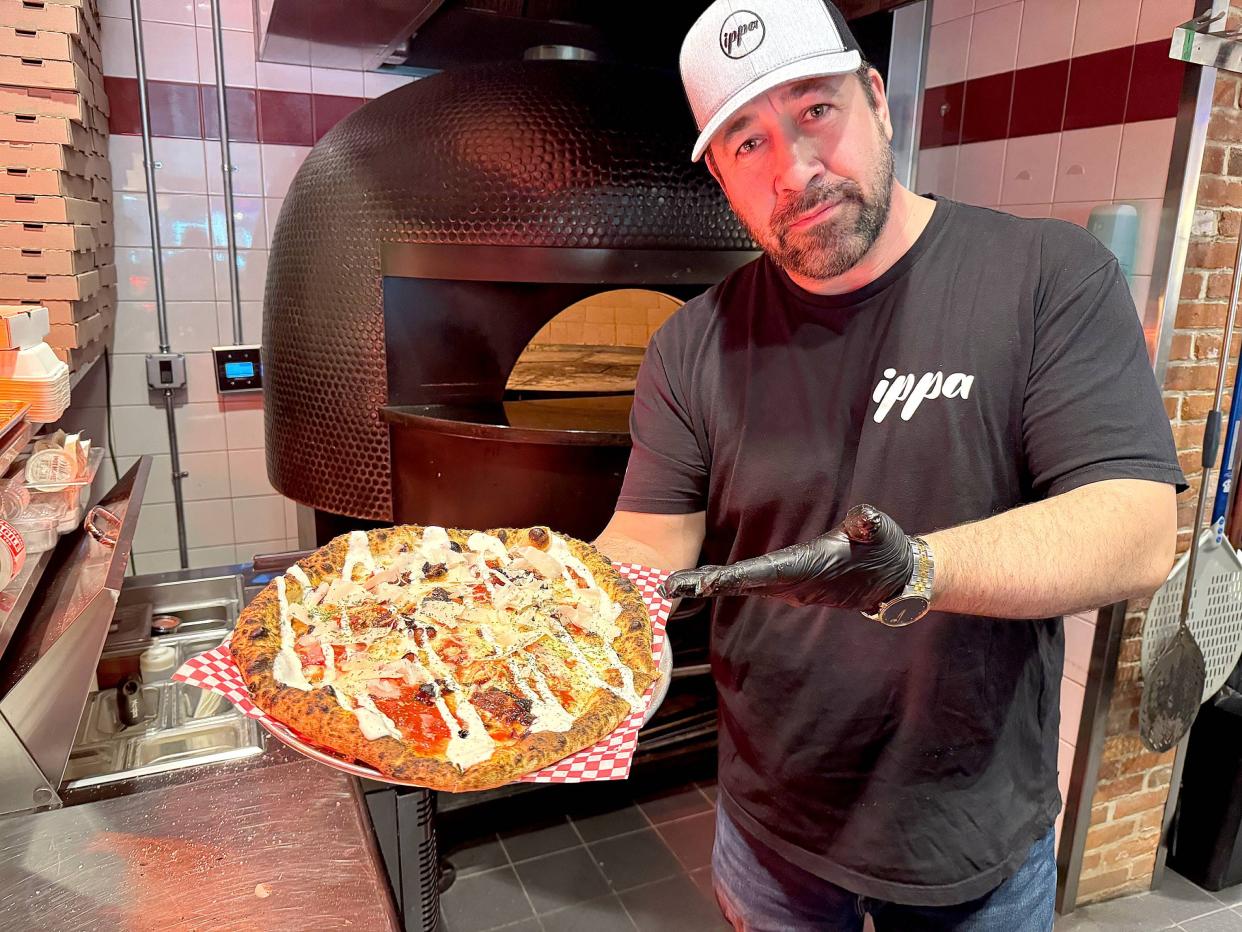 Jason Spore shows off his Chicken Bacon Ranch pizza from his brick oven at the Flagship City Food Hall.