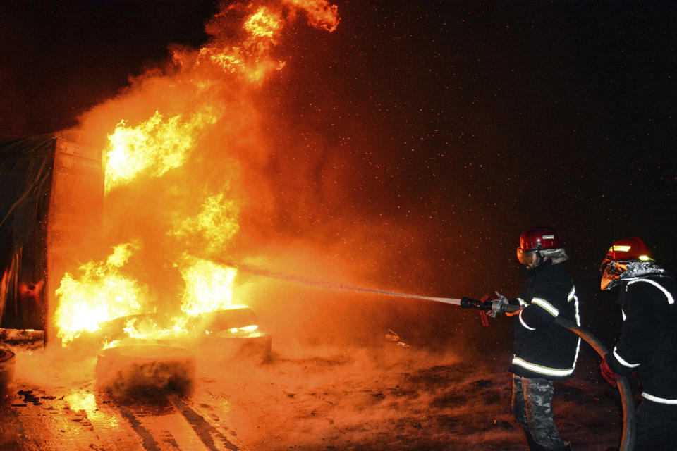 In this photo released by the Syrian official news agency SANA, firefighters work at the scene of a missile attack, at the seaport of the coastal city of Latakia, Syria, Tuesday, Dec. 28, 2021. Israeli missiles fired from the Mediterranean struck the Syrian port of Latakia early Tuesday, igniting a fire in the container terminal, Syrian state media reported, in the second such attack on the vital facility this month. (SANA via AP)