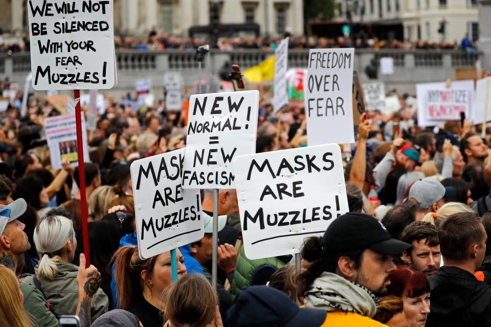 Protesters hold up placards as they gather in Trafalgar Square.