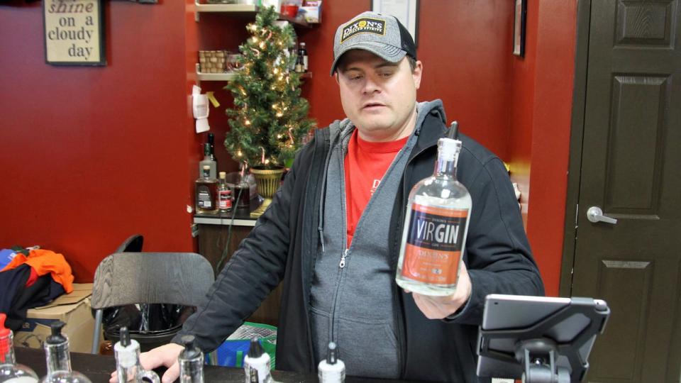 Chevy Patterson, co-owner of Dixon's Spirits, holds up a bottle of the locally made gin in the microdistillery's shop in Guelph. 