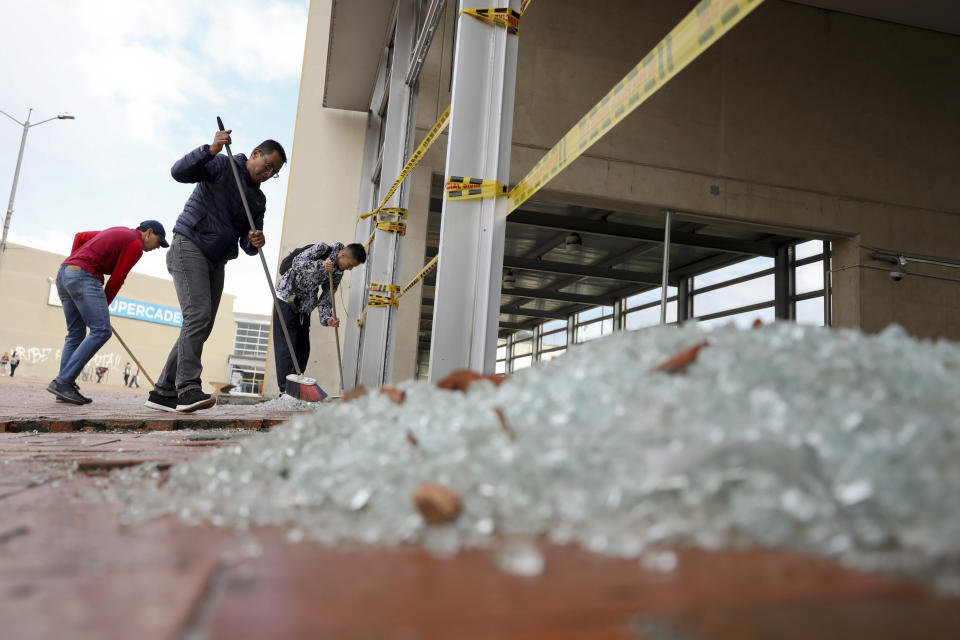 Los trabajadores limpian vidrios rotos de una estación de autobuses dañada por manifestantes antigubernamentales en Bogotá, Colombia, el viernes 22 de noviembre de 2019. (AP Foto / Fernando Vergara)