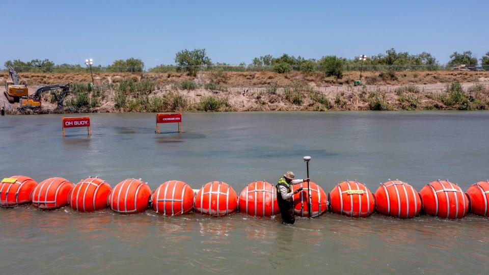 Buoys float on the Rio Grande River in Eagle Pass, Texas, on July 20, 2023, as a Mexican engineer with the International Boundary and Water Commission uses GPS determine to see whether the buoys are crossing into Mexican territory. The buoys were installed on orders by Texas Gov. Greg Abbott as an obstacle to prevent migrants from reaching the north embankment of the Rio Grande.