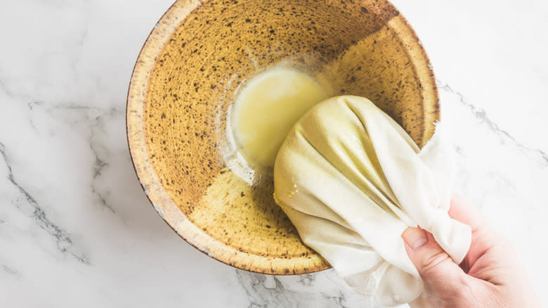 straining pistachio milk through cheesecloth