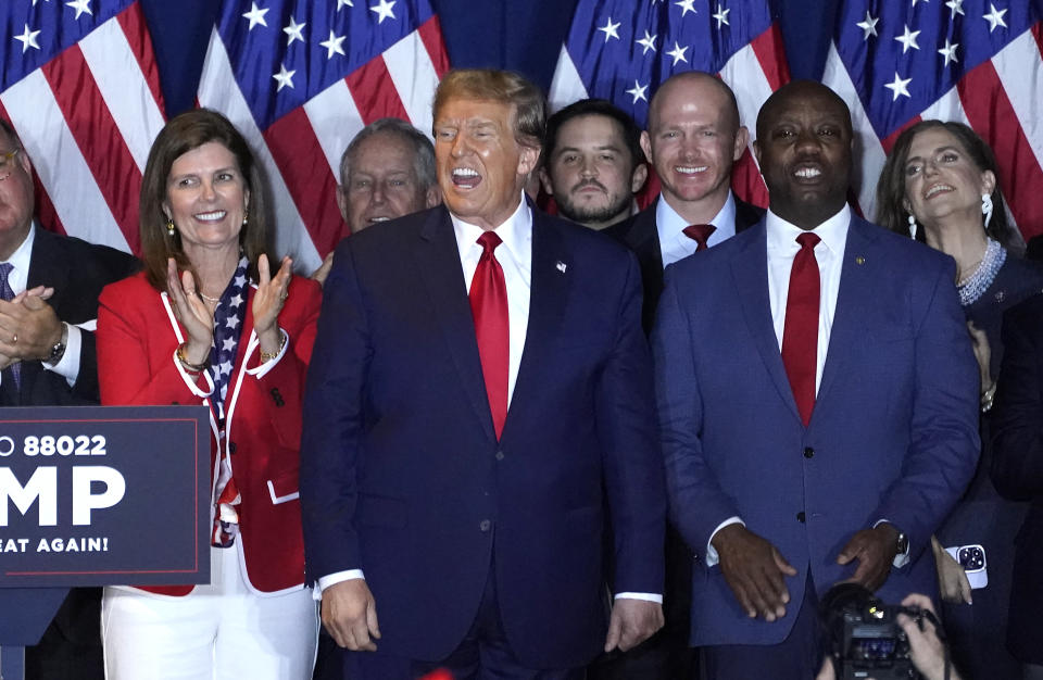 Former President Donald Trump, along with several other people, stands onstage at an election night watch party.