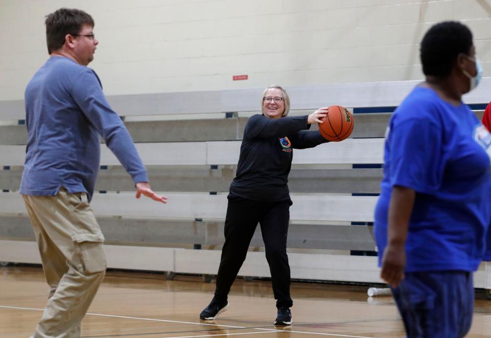 Kristin Schoonveld coaches her adopted son Nick Schoonveld's Special Olympics basketball team Tuesday, Dec. 7, 2021, at the Jewish Community Center in Indianapolis.