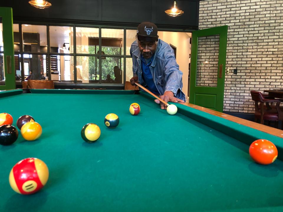 Gerald “Hollywood” Harris, a regular client of Milton Adult Day Services, shoots pool in the pub in the new Milton Village in South Bend.
