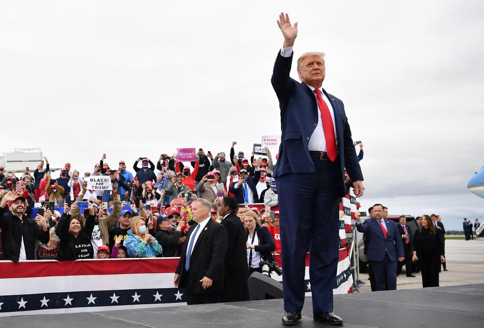 President Donald Trump waves as he arrives for a campaign rally at MBS International Airport in Freeland, Michigan.