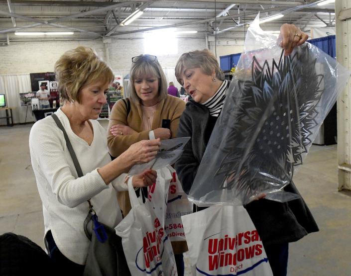 Luan Korosa, left, Jill Lehman and Dian Verbosky shop at Levengood Company during a visit Friday at the Stark County Home &amp; Garden Show at the Stark County Fairgrounds.