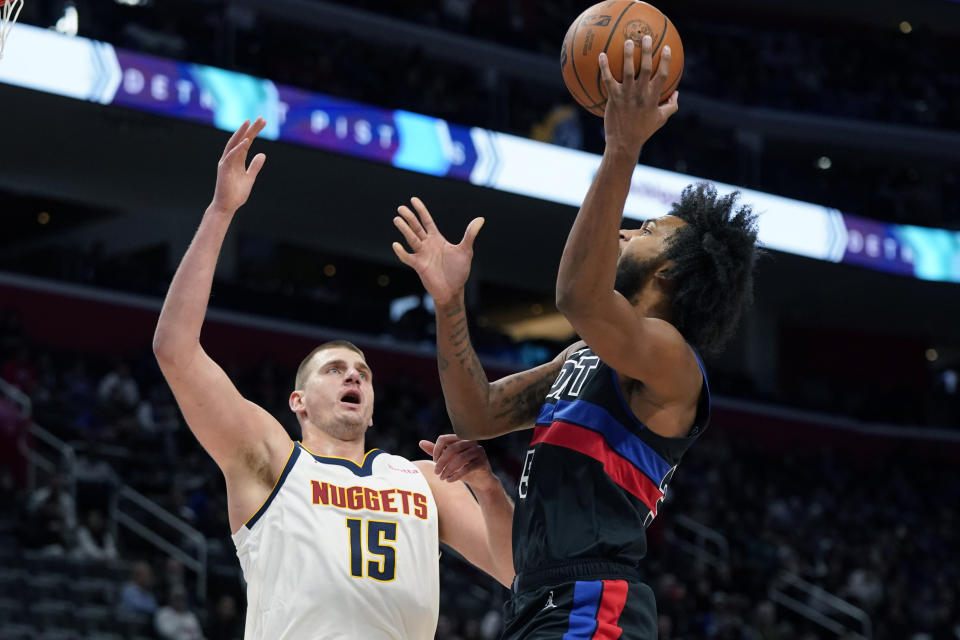 Detroit Pistons forward Marvin Bagley III (35) shoots over the defense of Denver Nuggets center Nikola Jokic (15) during the first half of an NBA basketball game, Monday, Nov. 20, 2023, in Detroit. (AP Photo/Carlos Osorio)