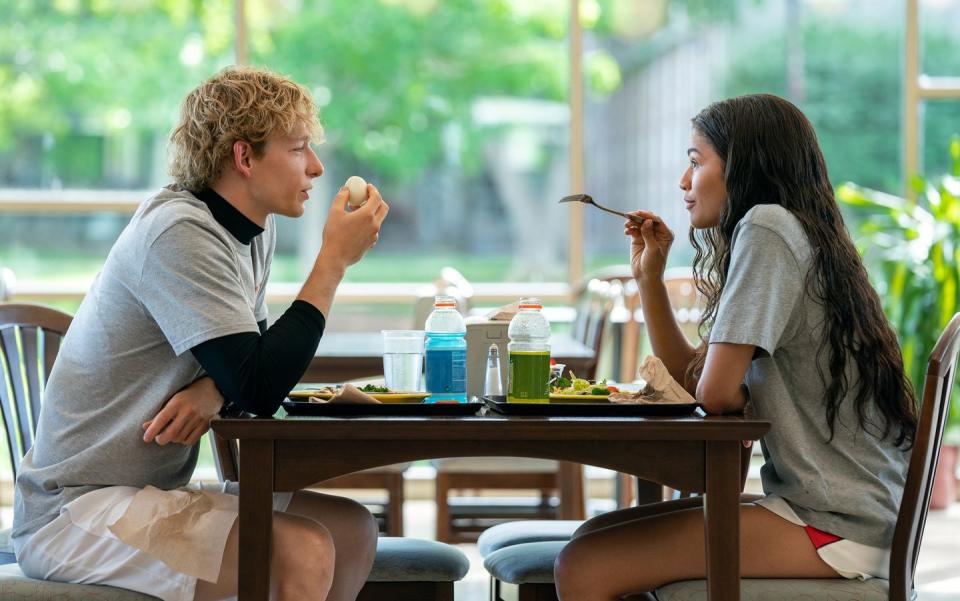mike faist as art, zendaya as tashi eating at a table together in challengers movie