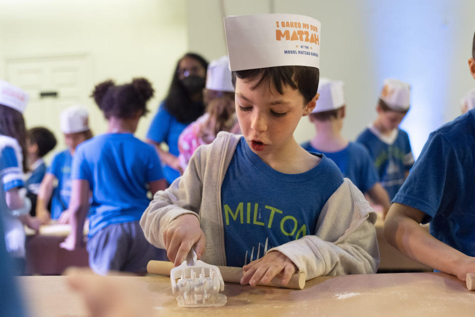 Ethan Pressberg, 6, a first grader at Milton Gottesman Jewish Day School of the Nation's Capital, uses a tool to make holes in dough for matzah during a "Matzah Factory" field trip at the JCrafts Center for Jewish Life and Tradition in Rockville, Md., Thursday, April 18, 2024, ahead of the Passover holiday which begins next Monday evening. To be kosher for Passover the dough has to be prepared and cooked all within 18 minutes and not allowed to rise. (AP Photo/Jacquelyn Martin)