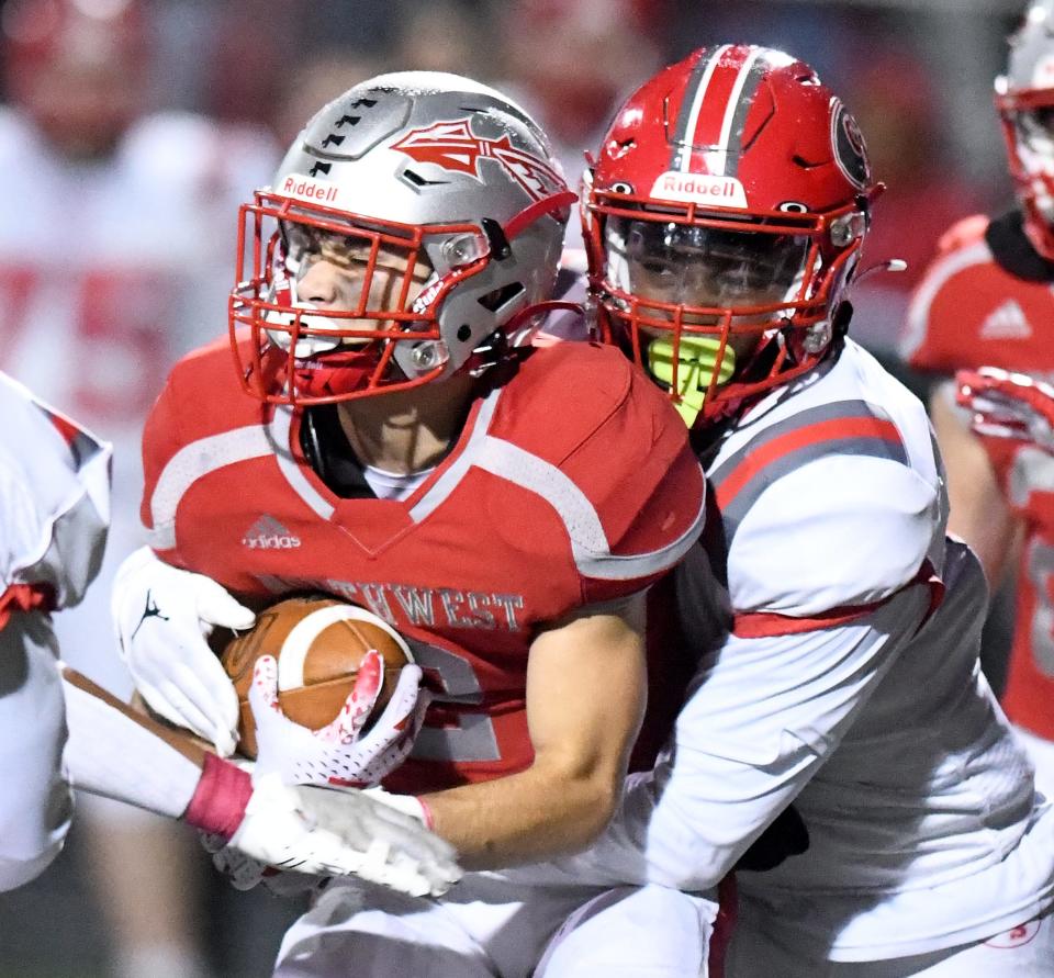 Northwest's Chase Badger is wrapped up by Canton South defensive back Ma'Taeaun Frazier in the second quarter at Northwest football. Friday, Oct. 20, 2023.