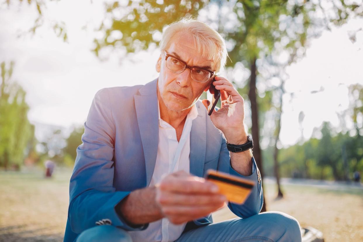 Senior man phoning the bank for credit card support.