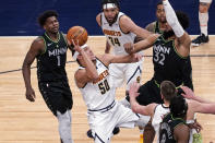 Denver Nuggets' Aaron Gordon (50) shoots as Minnesota Timberwolves' Karl-Anthony Towns (32) defends and Anthony Edwards (1) watches during the first half of an NBA basketball game Thursday, May 13, 2021, in Minneapolis. (AP Photo/Jim Mone)