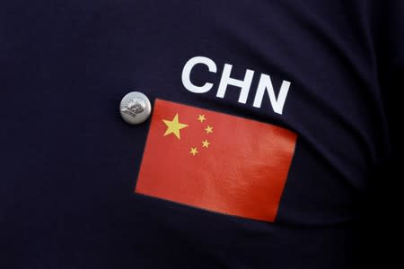 A man wears a button depicting the late Chinese Chairman Mao Zedong on a T-shirt with the Chinese national flag in Tiananmen Square in Beijing