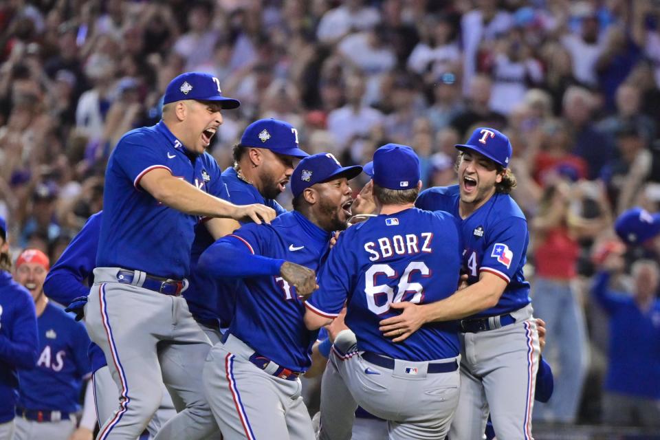 Rangers players celebrate on the field after the final out of Game 5.
